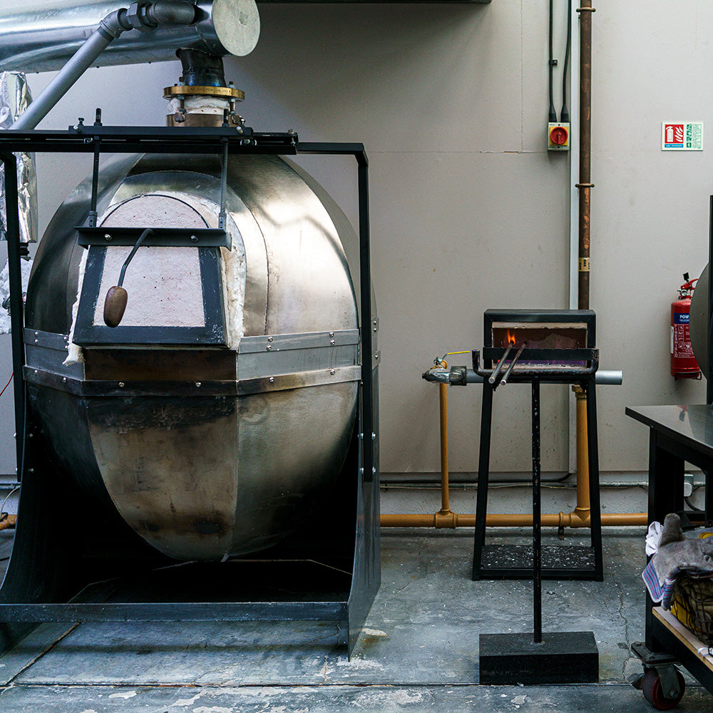 A Glass Blowing Furnace with a pipe in a hand blowing Glass workshop of UK glass artist Michael Ruh