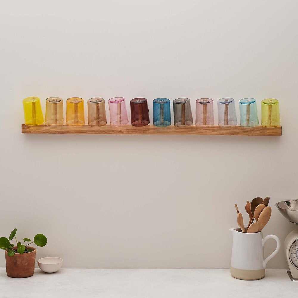 twelve coloured glasses on bar rack